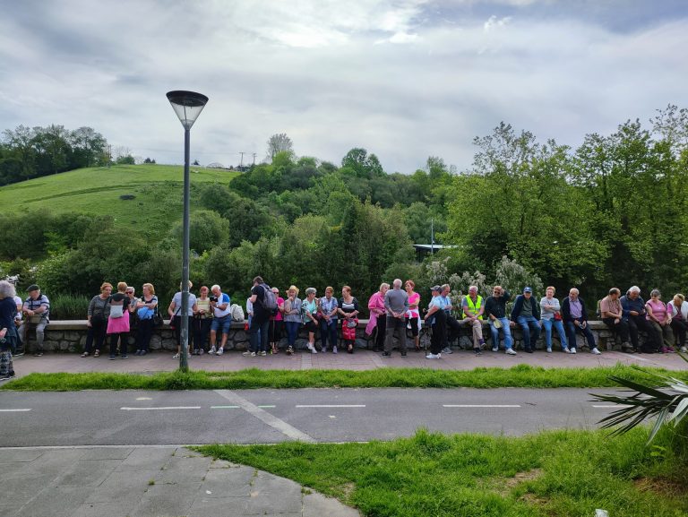 Grupo de personas descansando sentadas sobre un petril