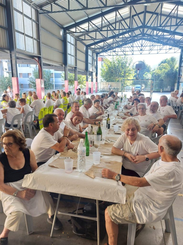 Multitud sentada alrededor de mesas con comida