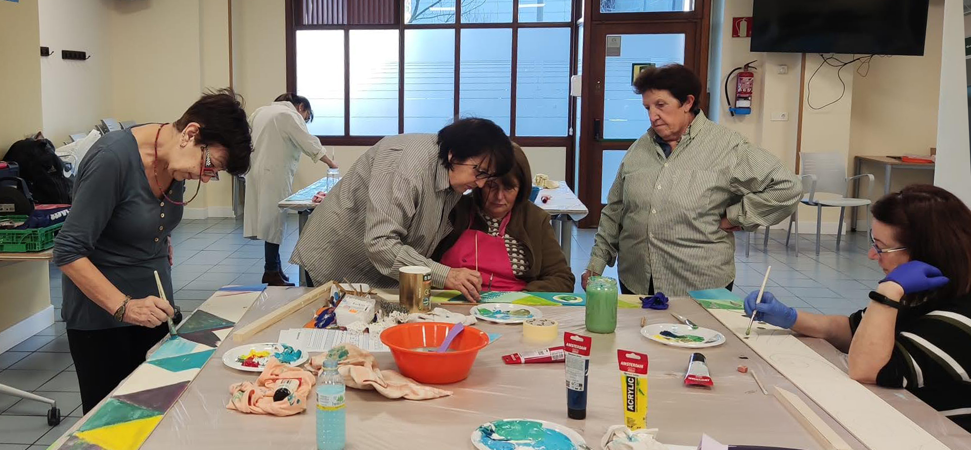 varias mujeres pintando sobre una mesa