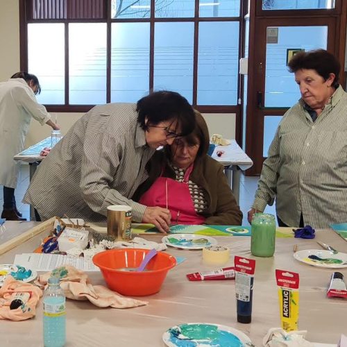 varias mujeres pintando sobre una mesa