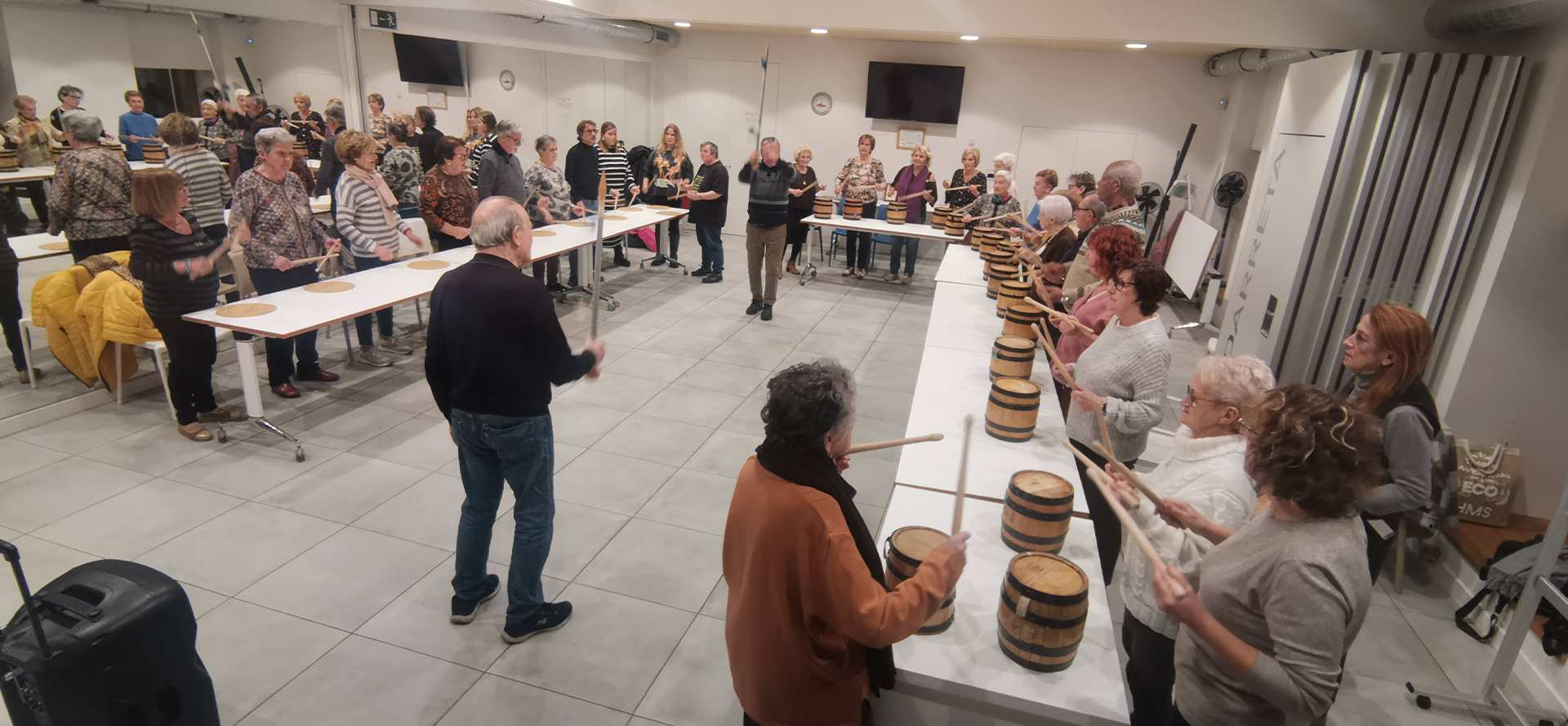 grupo numeroso de personas tovando barriles en el interior de la asociacion