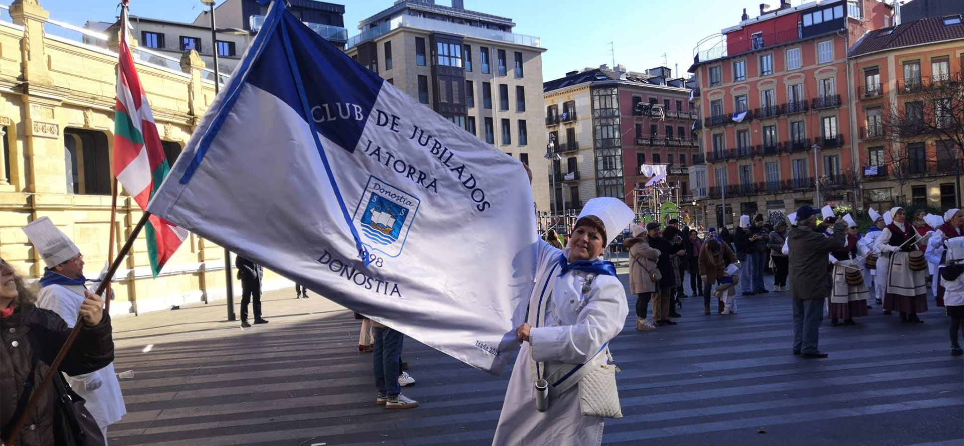 mujer sujetando la bandera de Donostia