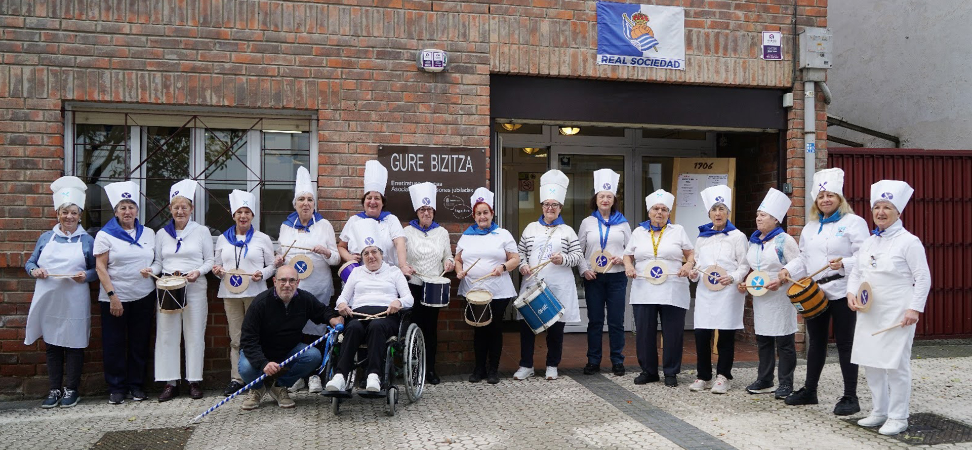 grupo de personas vestidos de tamborreros en el exterior de la asociacion