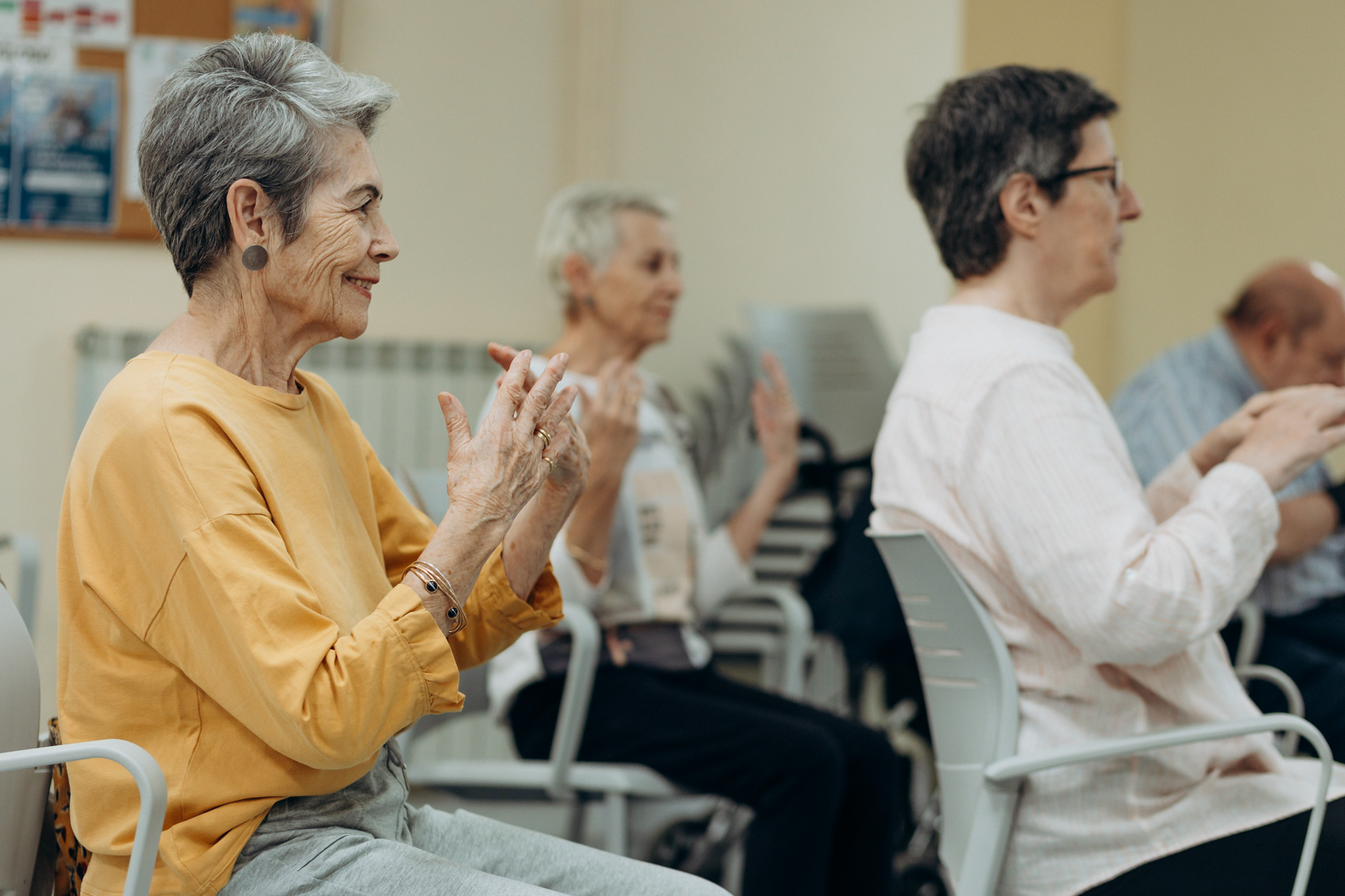 Grupo de personas sentadas en una silla movilizando las muñecas y las manos