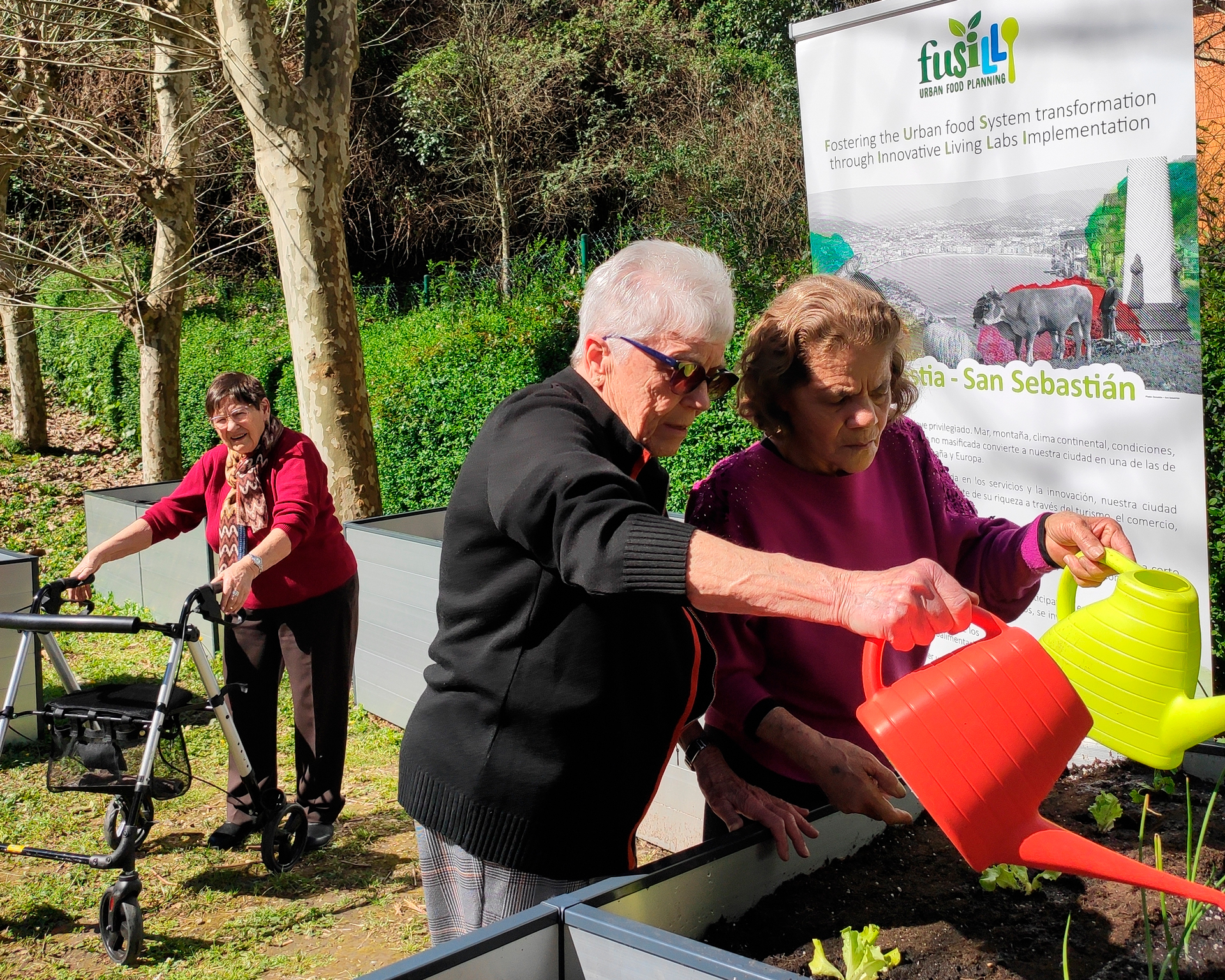 Dos personas regando una huerta con regaderas
