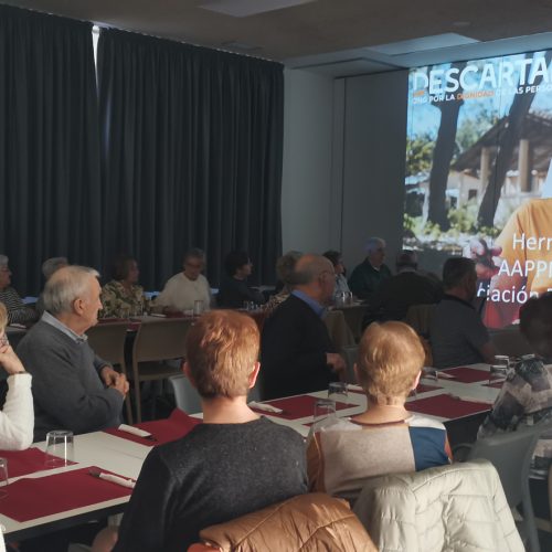 Grupo de personas en una sala mirando una proyección