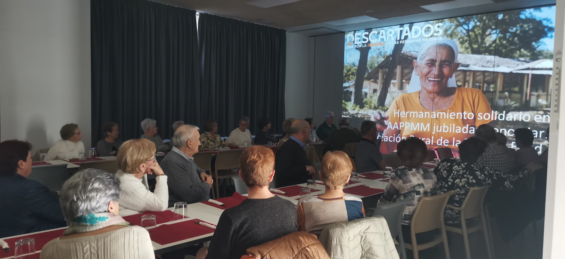 Grupo de personas en una sala mirando una proyección