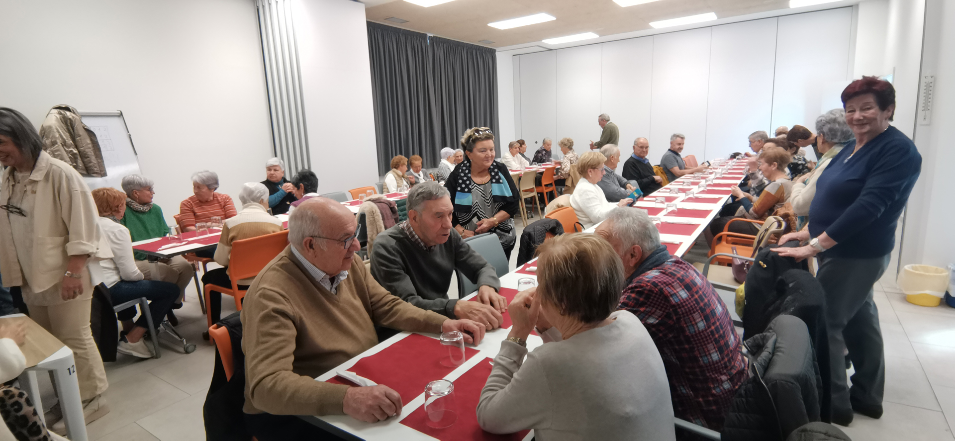 Grupo de personas sentadas alrededor de mesas listas para comer