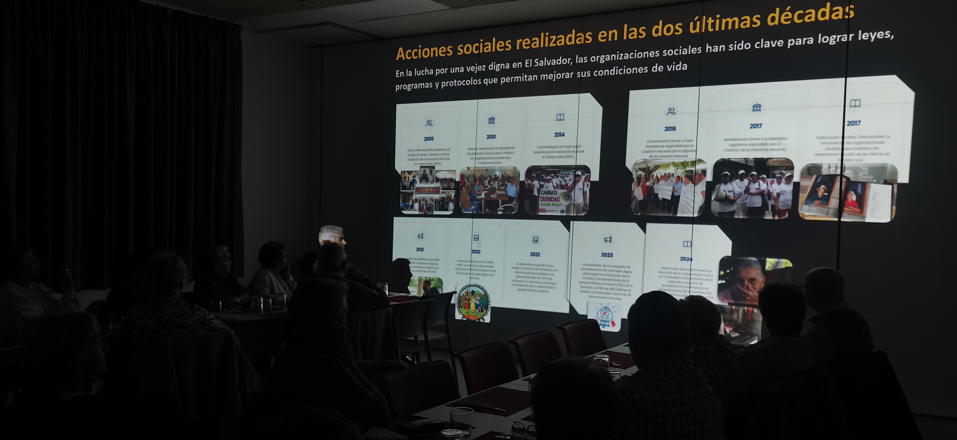 Grupo de personas en una sala mirando una proyección