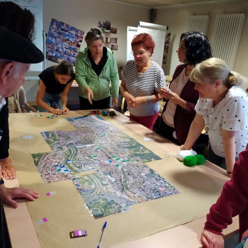 Varias personas reunidas alrededor de una mesa con un mapa central