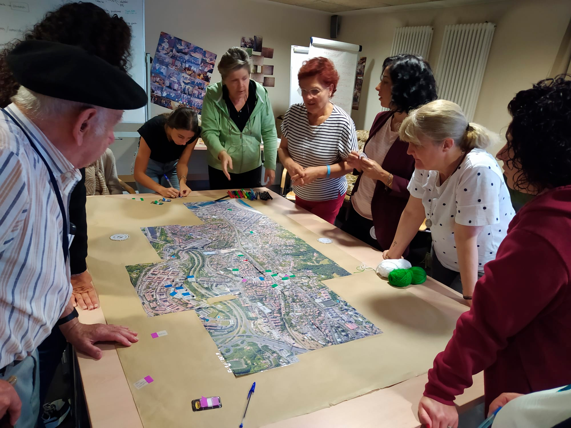 Varias personas reunidas alrededor de una mesa con un mapa central