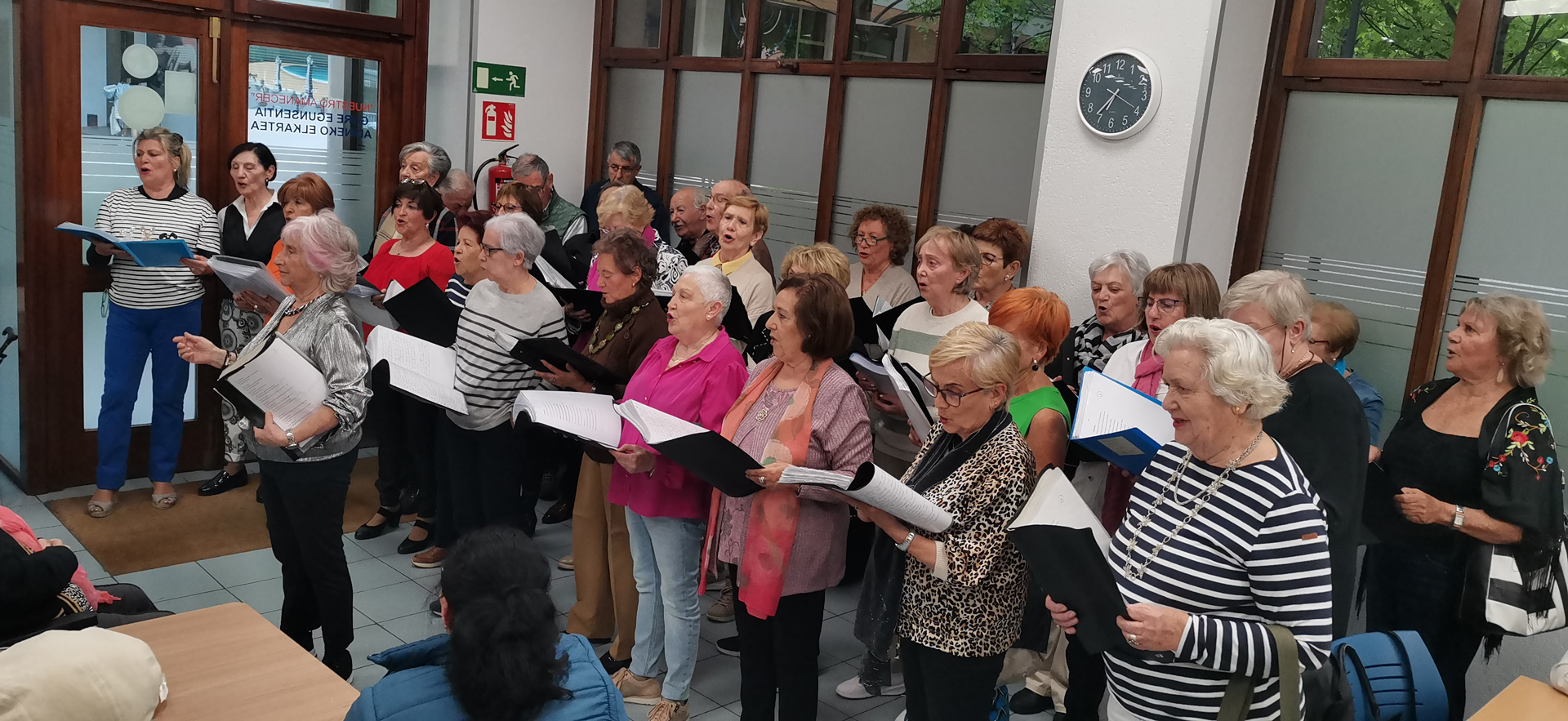 Grupo de personas cantando con partituras