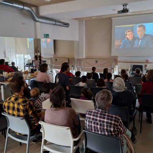 Grupo de personas frente a una pantalla de cine