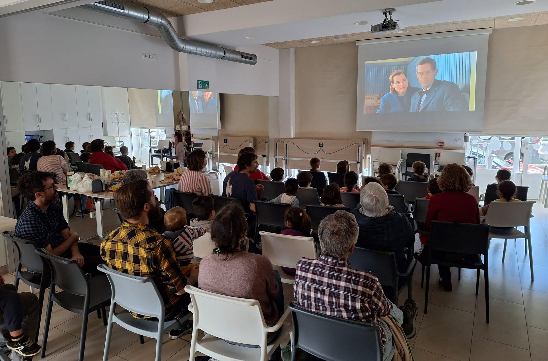 Grupo de personas frente a una pantalla de cine