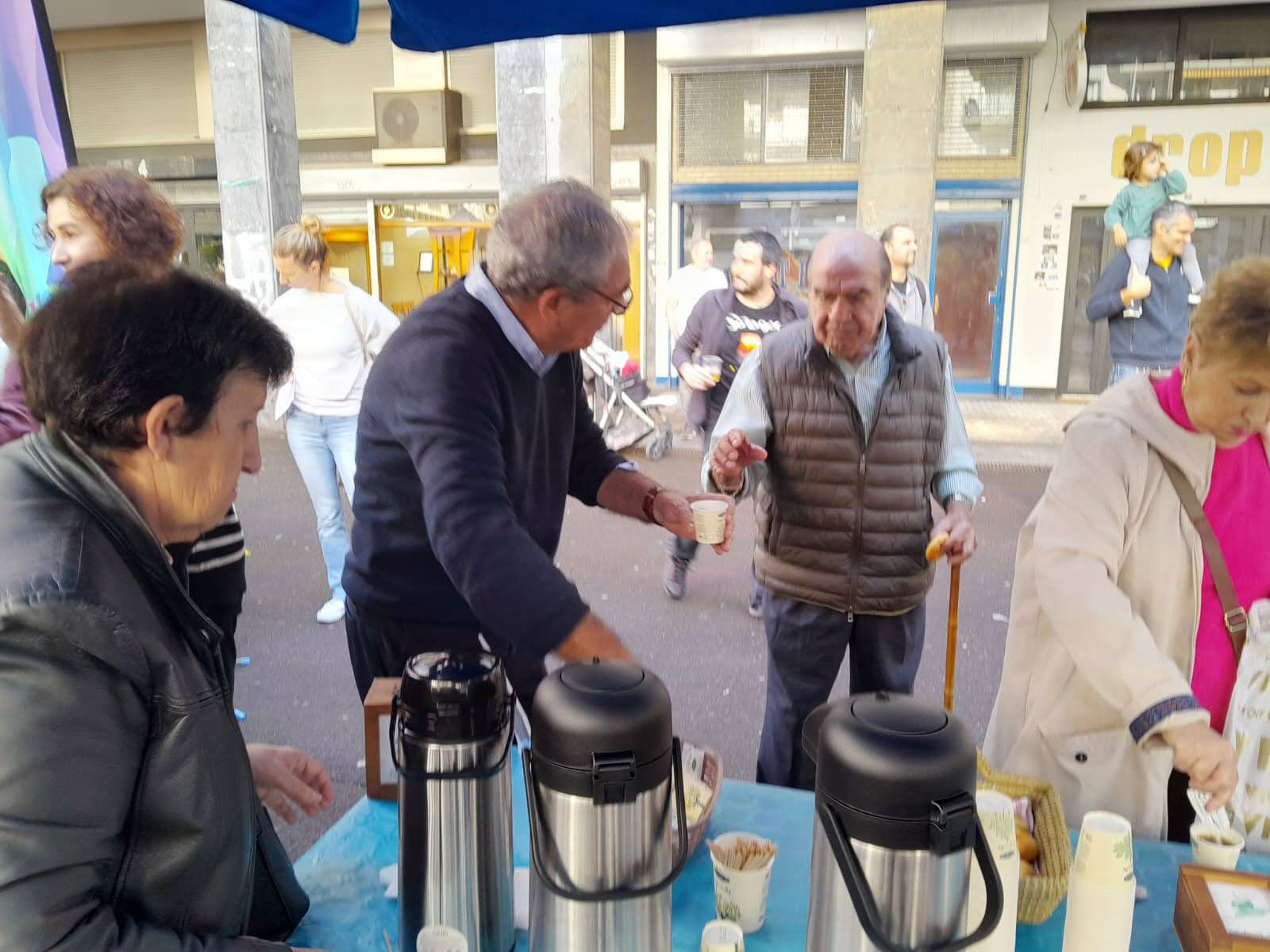 Varias personas ofreciendo café en una plaza