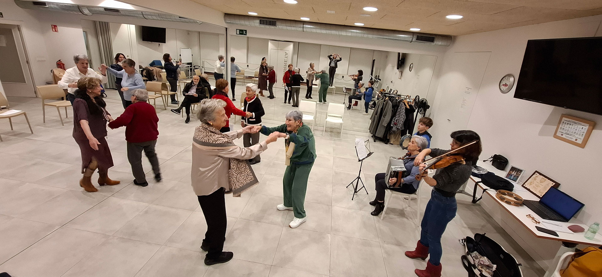 Grupo de personas bailando mientras otras personas tocan instrumentos