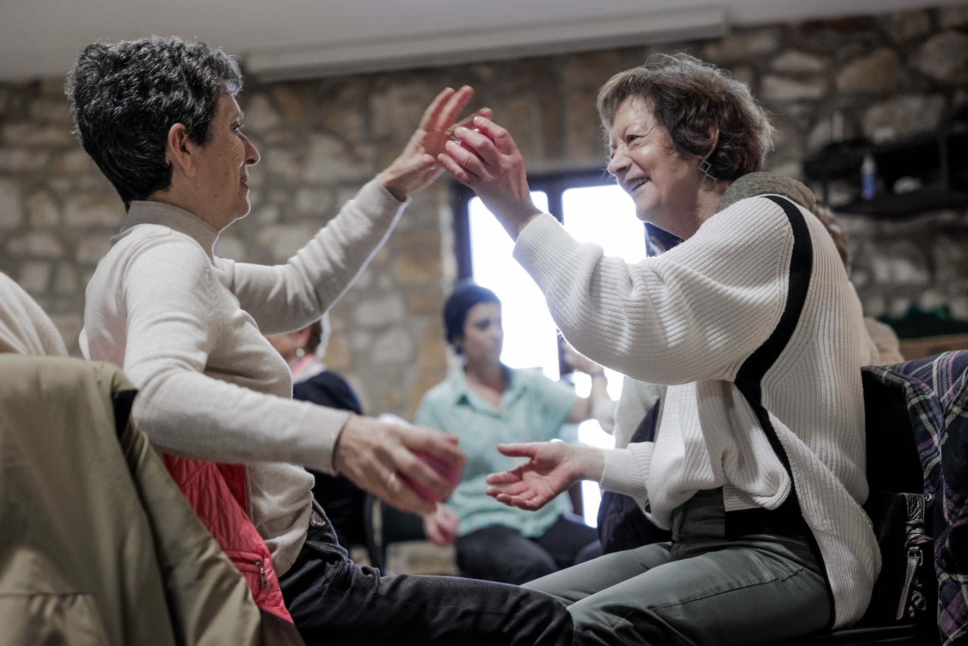 Dos personas intercambiando una pelota y riéndose