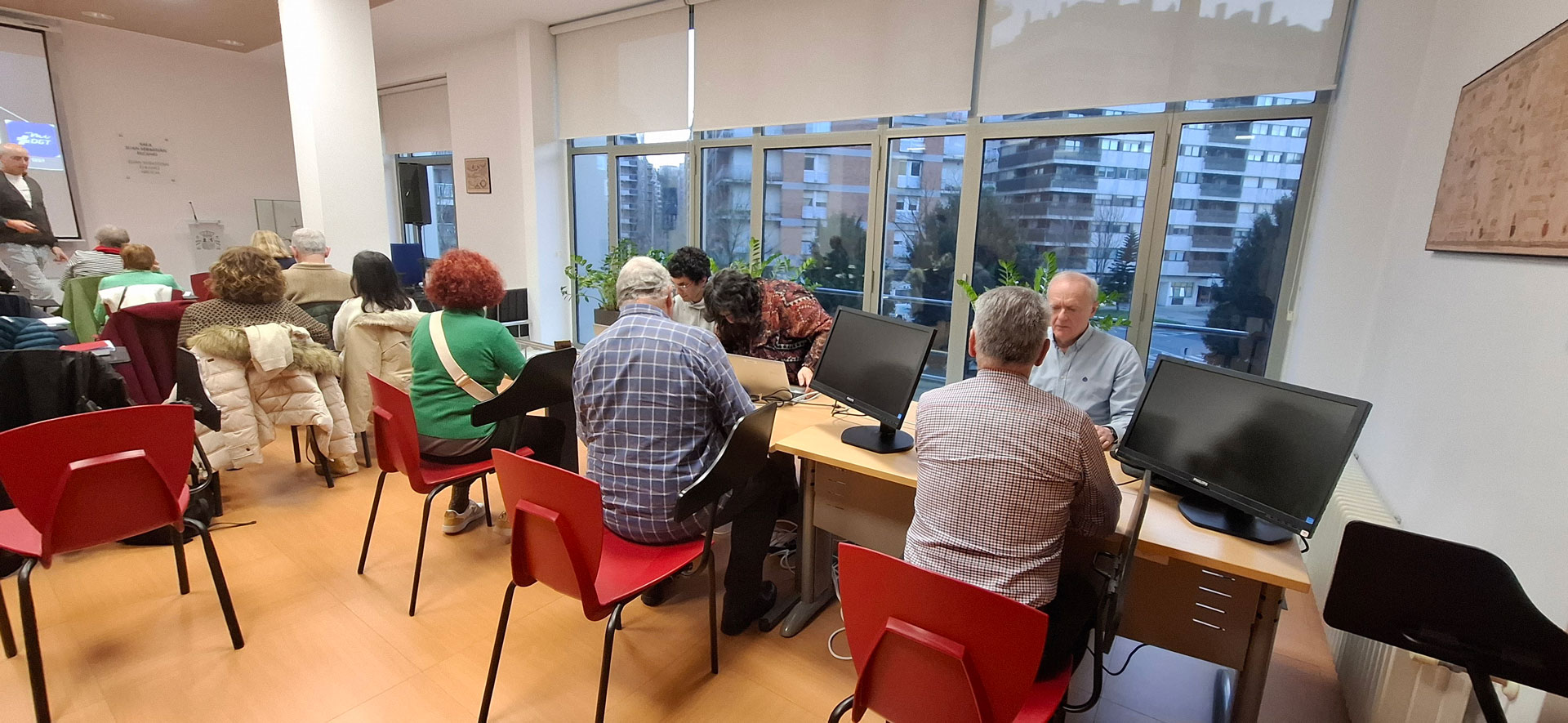Grupo de personas alrededor de una mesa trabajando en ordenadores