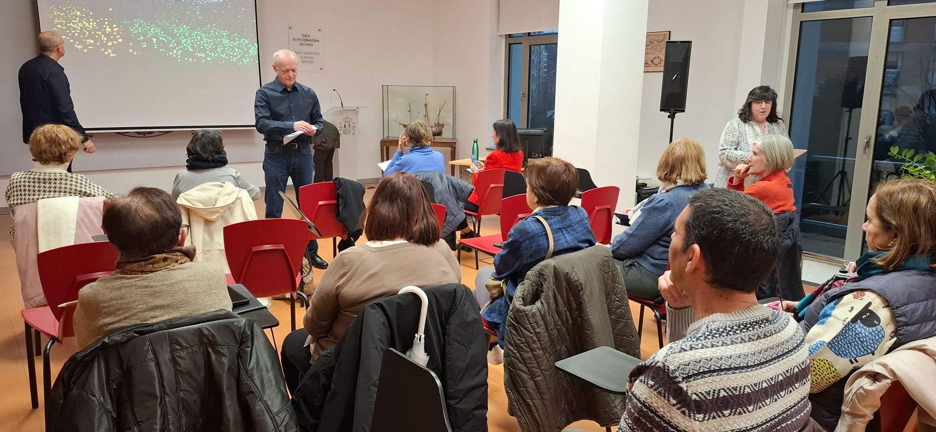 Grupo de personas sentada frente a un ponente en una sala