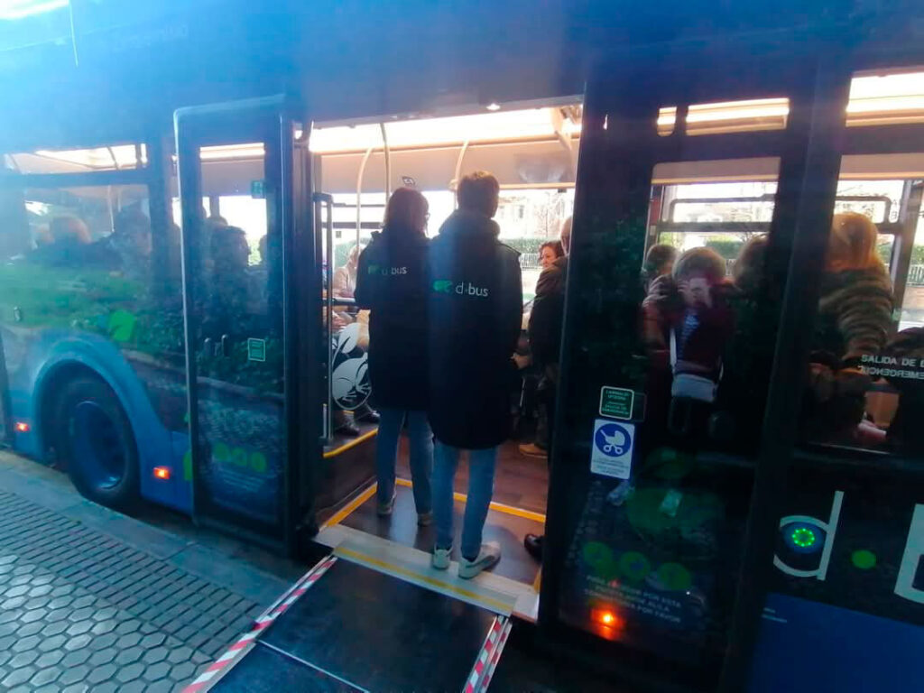 Un autobús parado con las puertas abiertas y gente dentro.