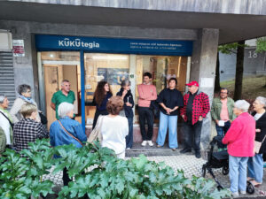 Varias personas reunidas en la calle frente a un local