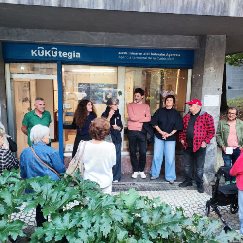 Varias personas reunidas en la calle frente a un local