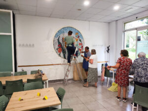 Varias personas en una sala colocando un mosaico gigante en la pared