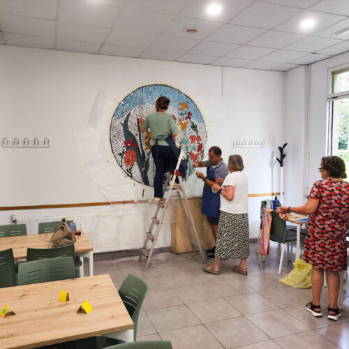 Varias personas en una sala colocando un mosaico gigante en la pared