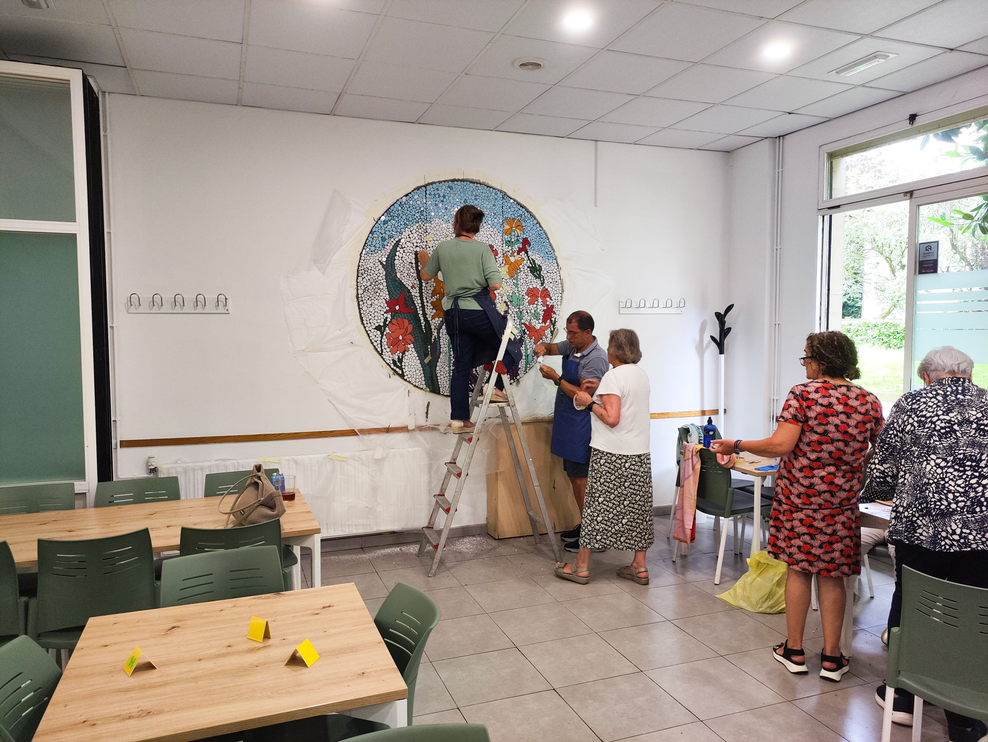 Varias personas en una sala colocando un mosaico gigante en la pared