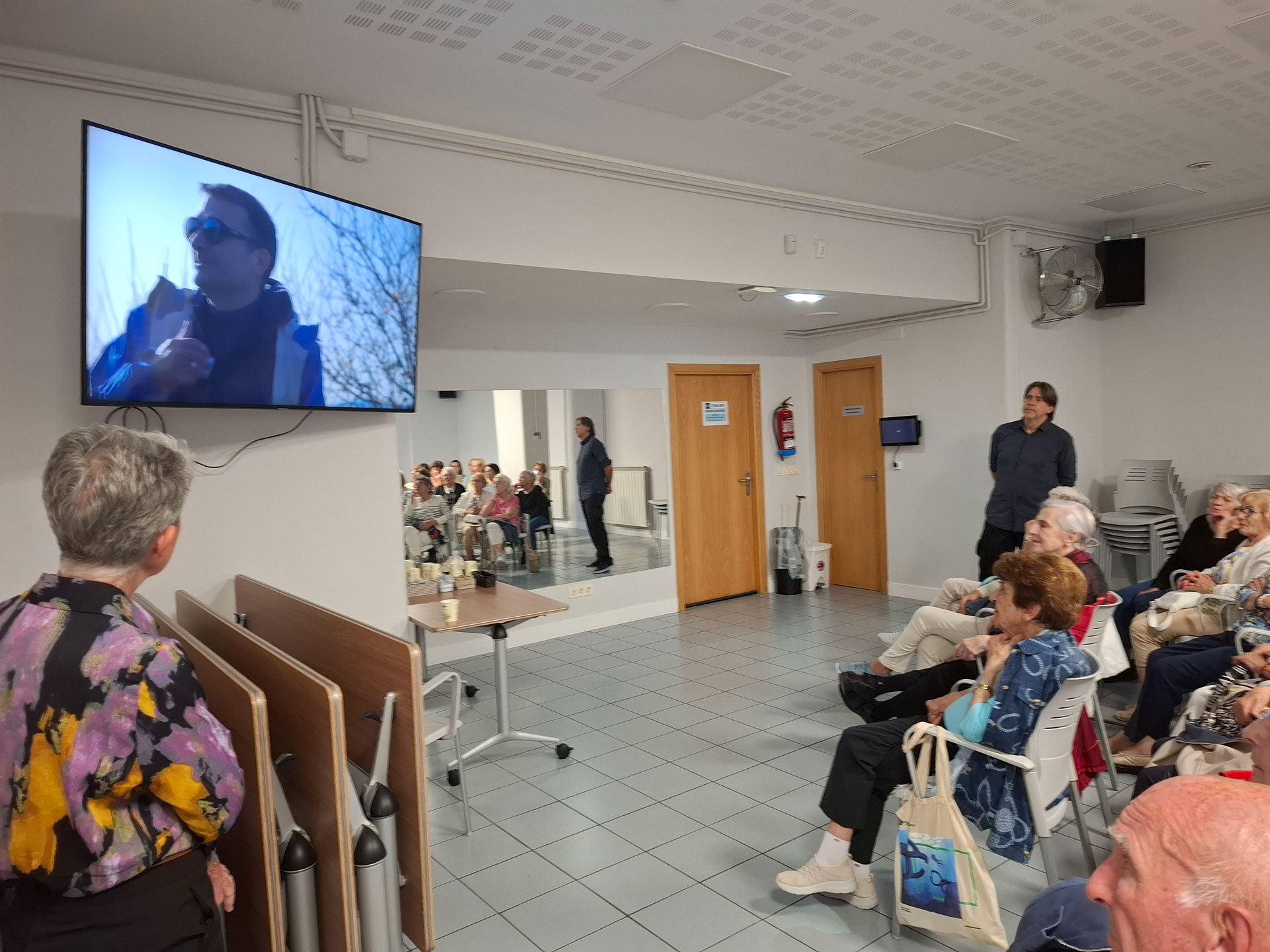 Grupo de personas reunido frente a una pantalla