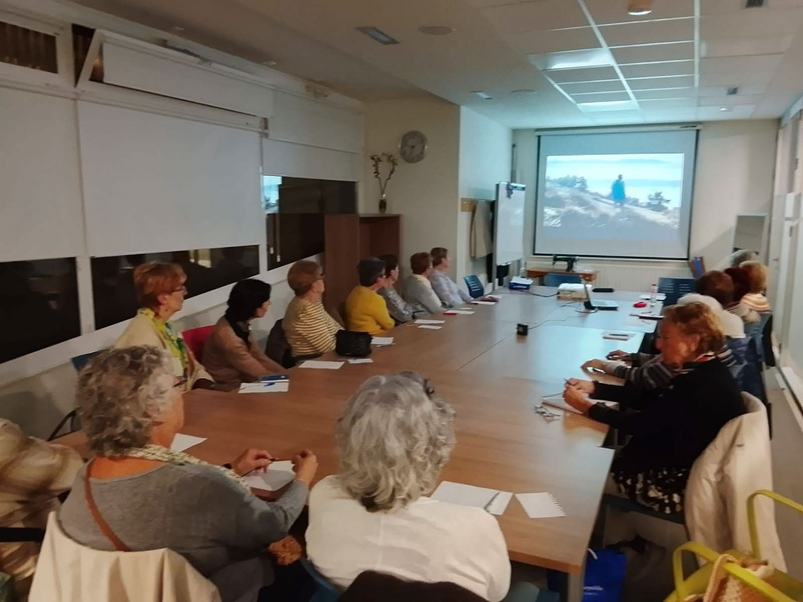 Grupo de personas reunido frente a una pantalla