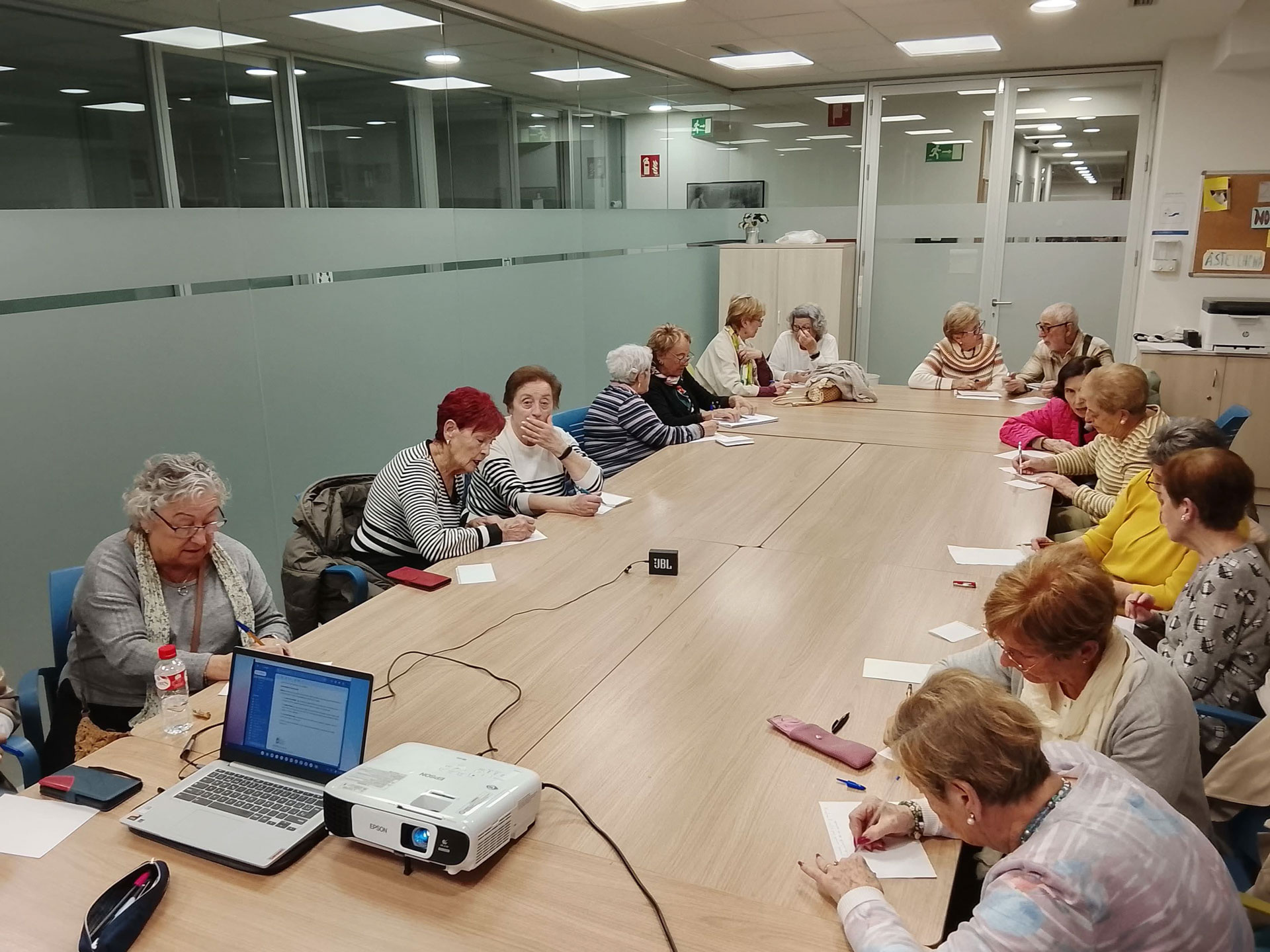 Grupo de personas reunido frente a una pantalla