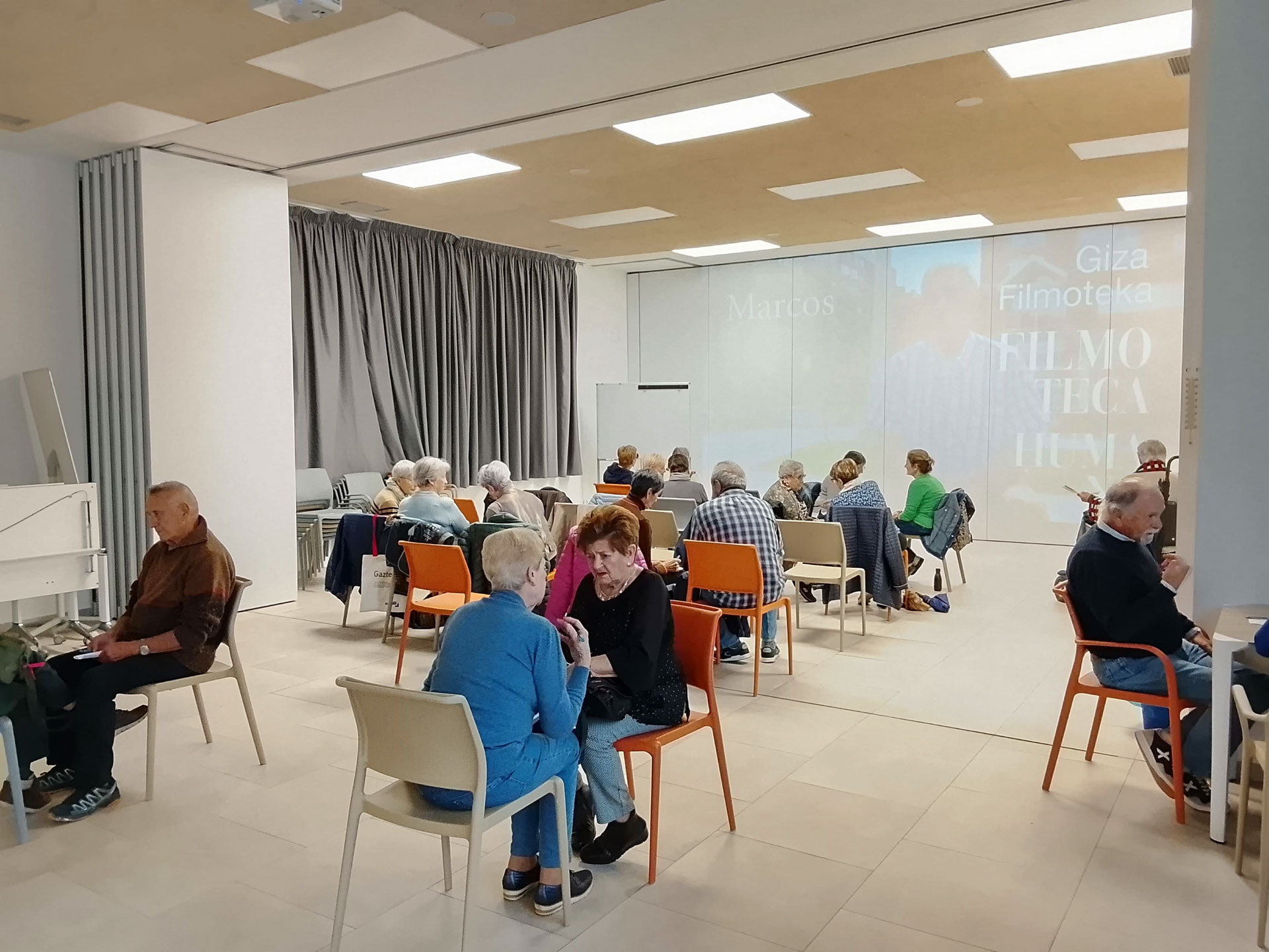 Grupo de personas reunido frente a una pantalla