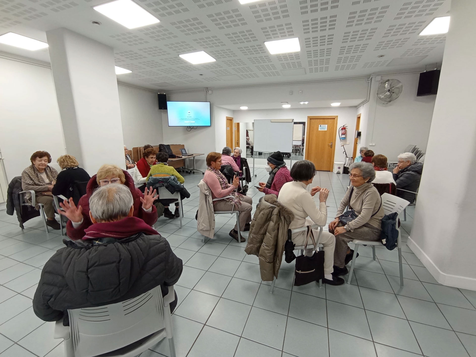 Grupo de personas reunido frente a una pantalla