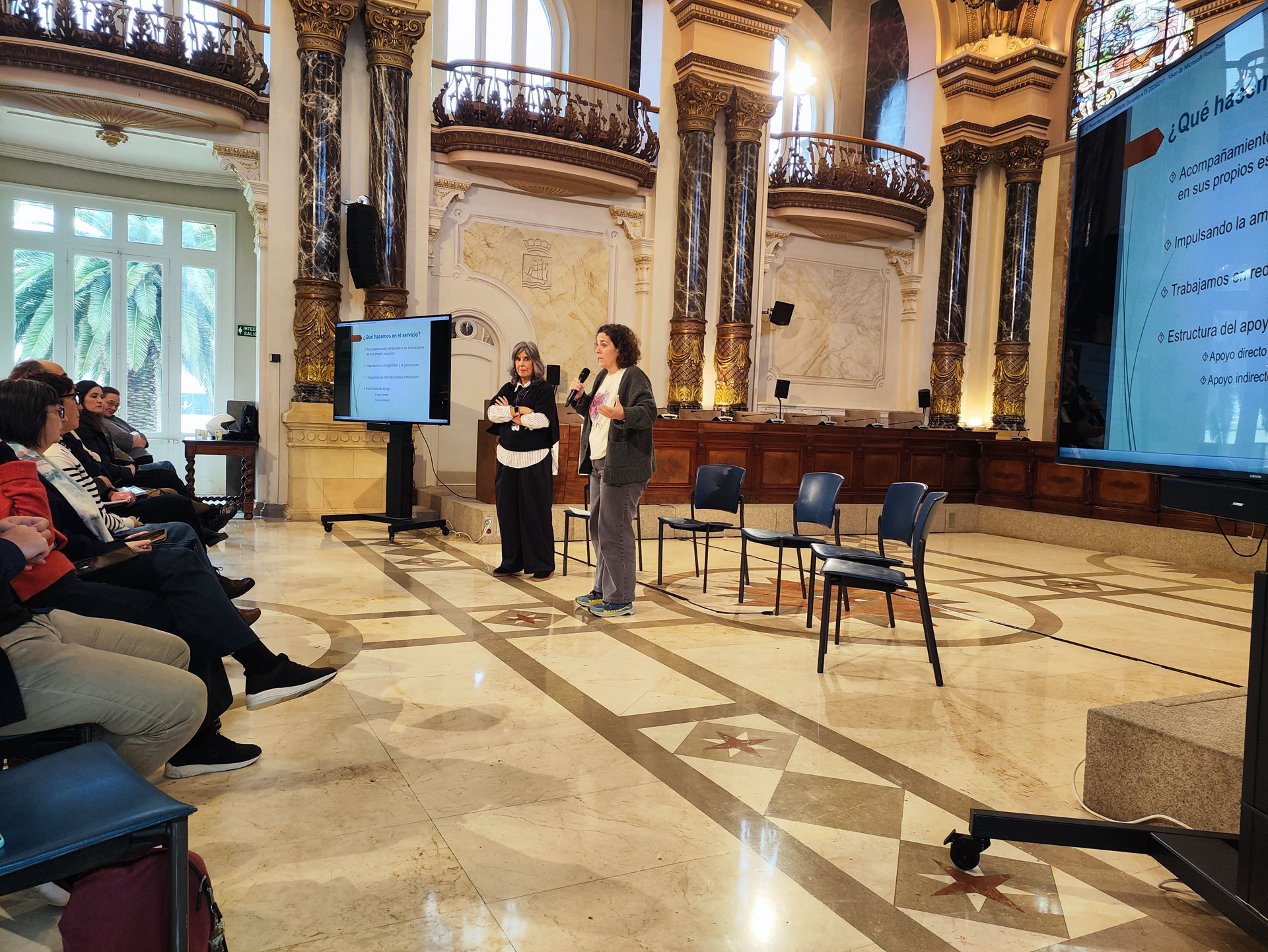 Dos personas presentando con un micrófono