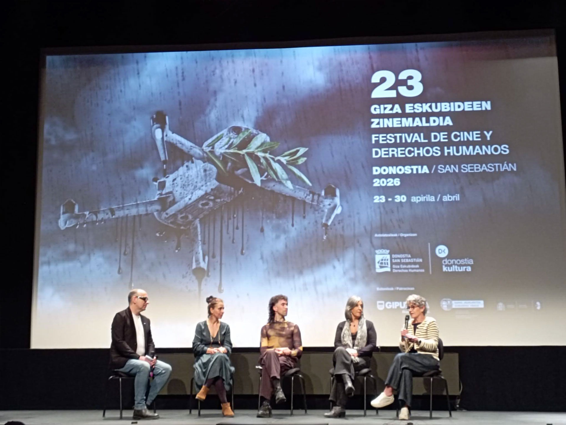 Cinco eprsonas frente a una pantalla de cine con imagen