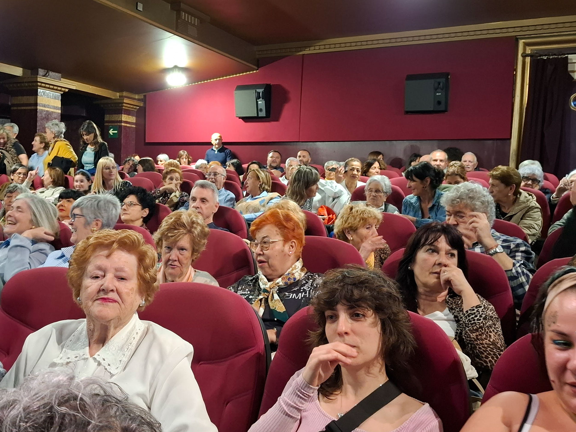 Salón de butacas de cine llena de personas