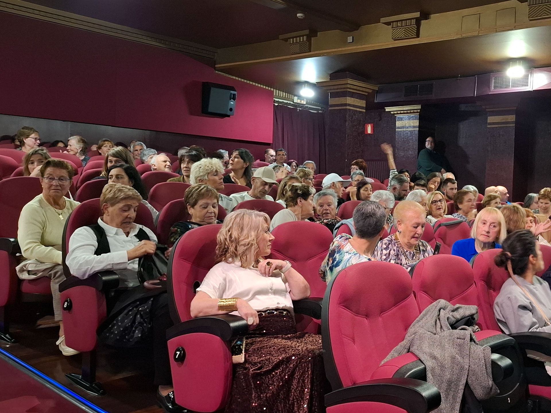 Salón de butacas de cine llena de personas
