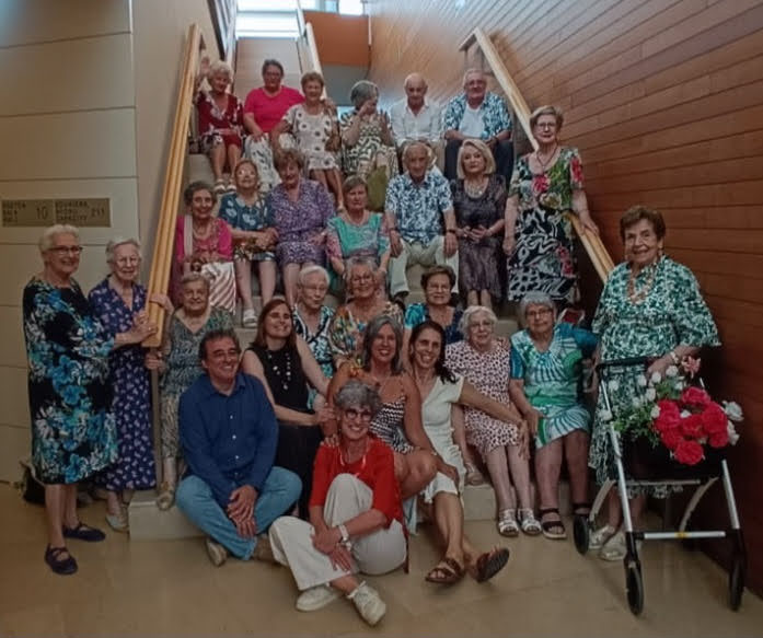 Grupo de personas posando sentadas en una escalera