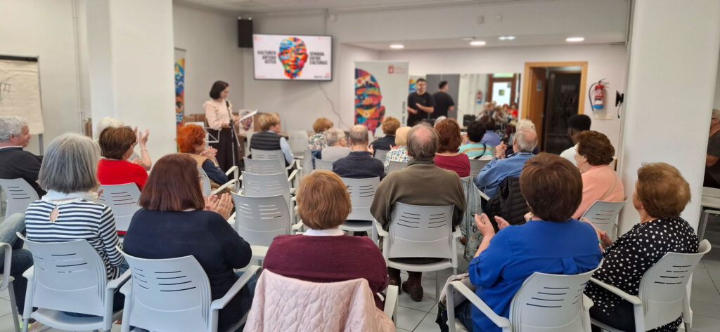grupo de personas escuchando a ponentes en una sala